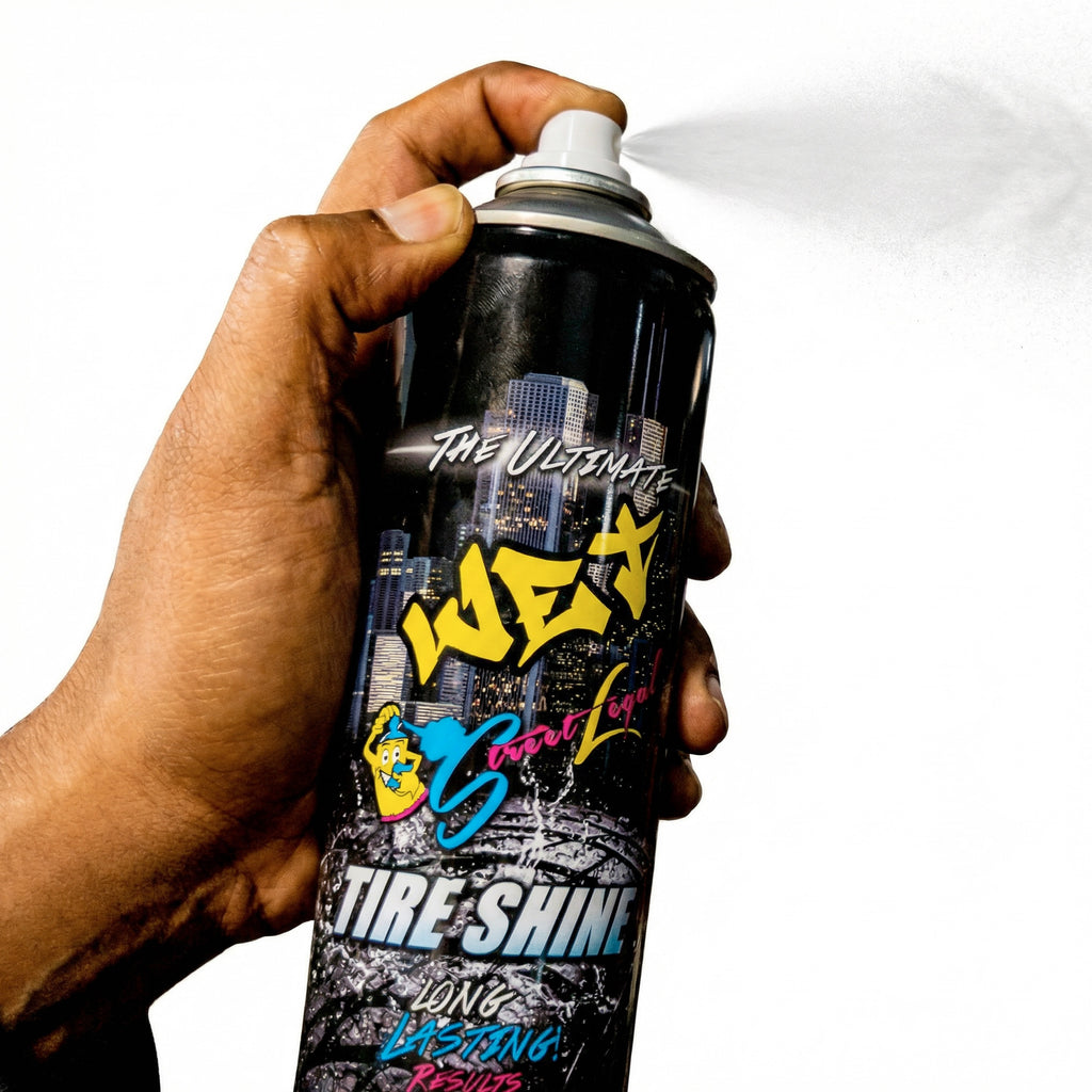 Hand holding a can of 'The Ultimate Wax' tire shine with colorful text on a white background